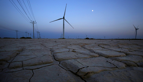 Cracked earth marks a dried-up area near a wind turbine used to generate electricity at a wind farm in Guazhou, 950km (590 miles) northwest of Lanzhou, Gansu Province