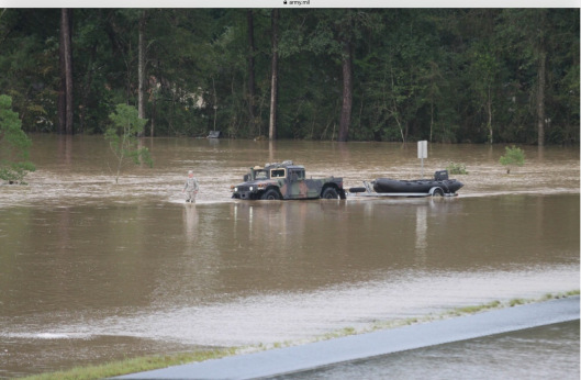 A Louisiana National Guardsman guiding a Humvee through floodwaters off of I-12 outside of Denham Springs. (Photo Credit: Spc. Garrett L. Dipuma, Army National Guard )